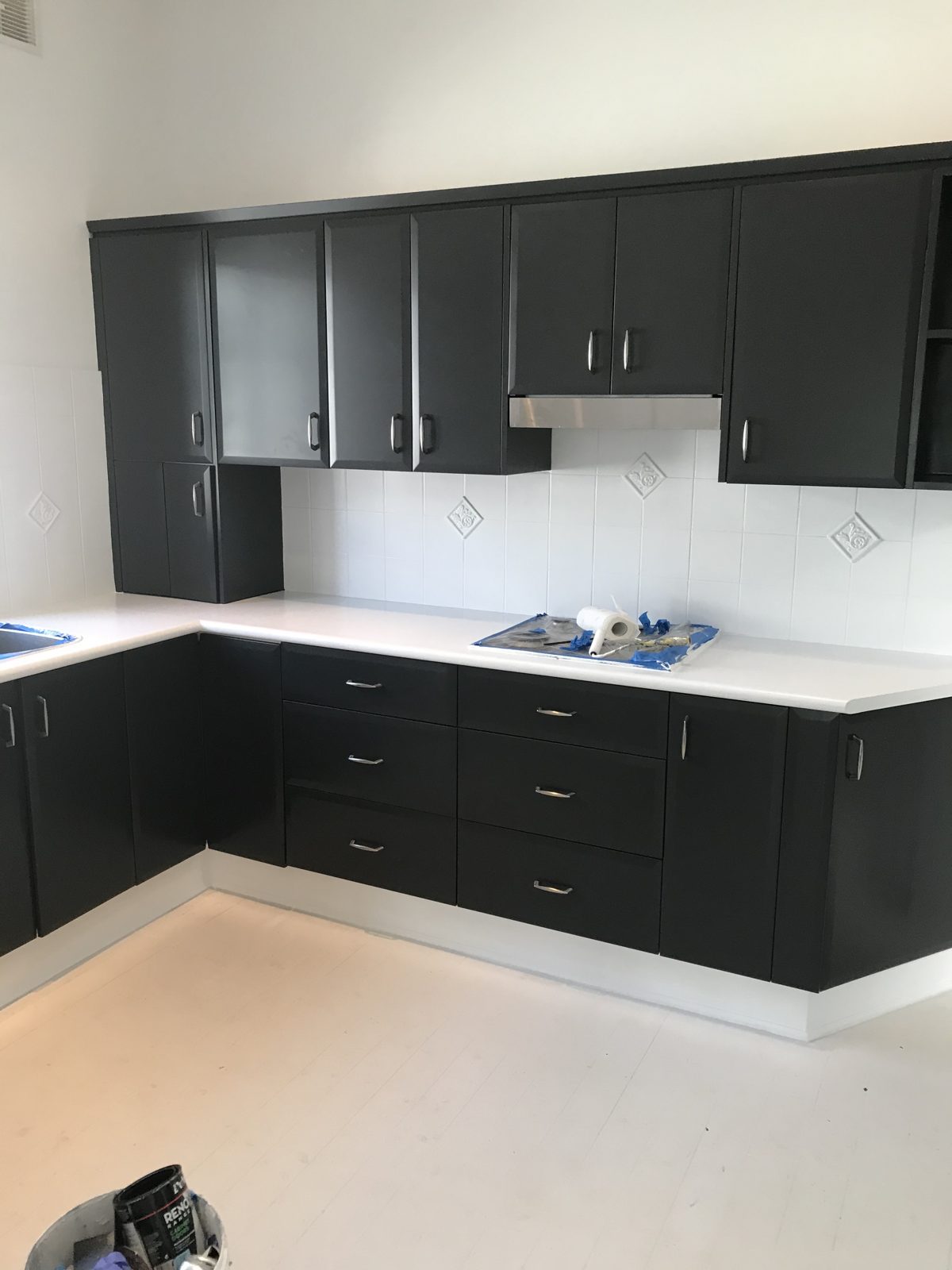A kitchen after its cabinets were repainted charcoal
