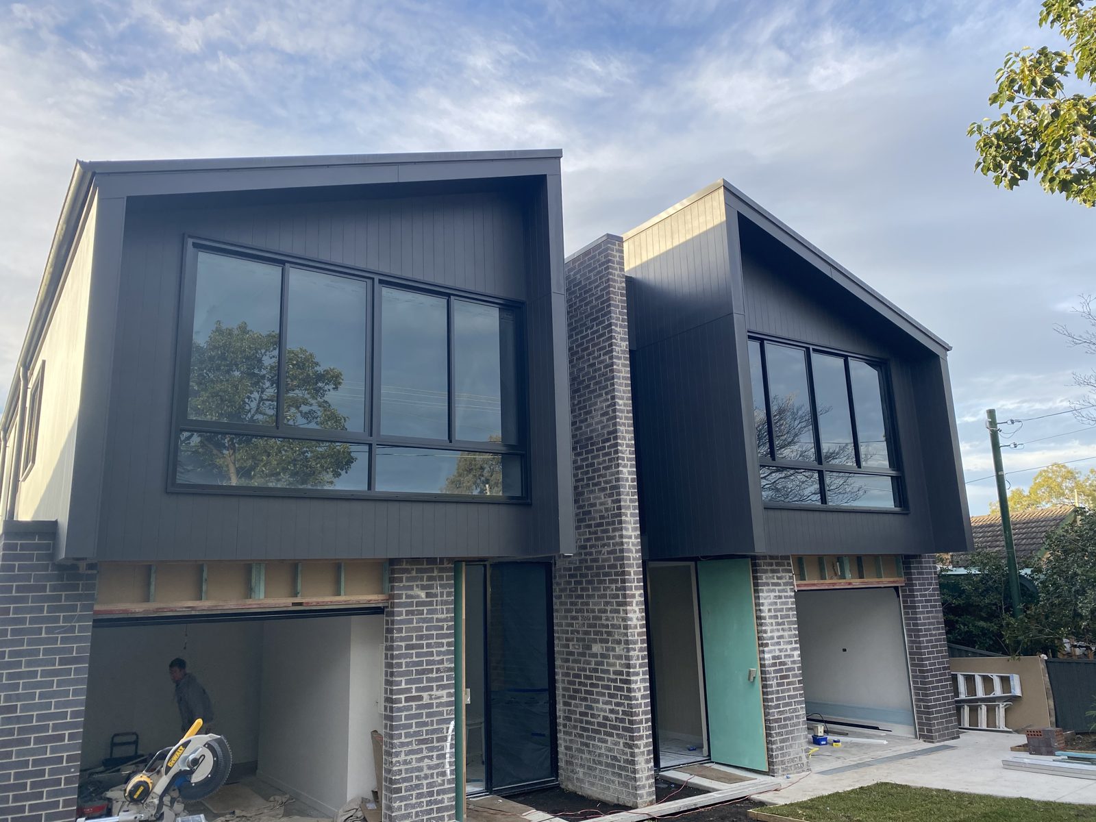 A large two-home build being painted and finished over a long project